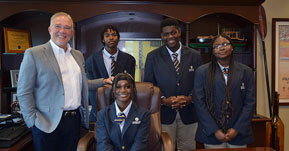 Photo of Bank CEO, Luis de la Aguilera, with 4 student interns from Cristo Rey Miami High School
