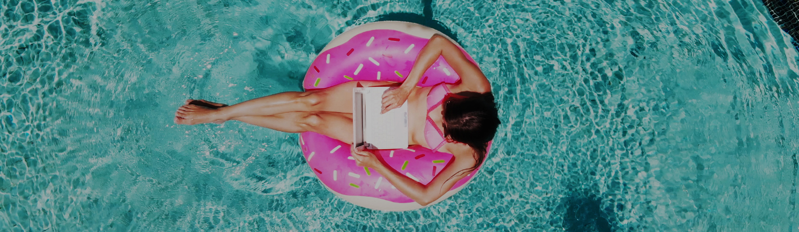 woman inside a pink inflatable at the pool