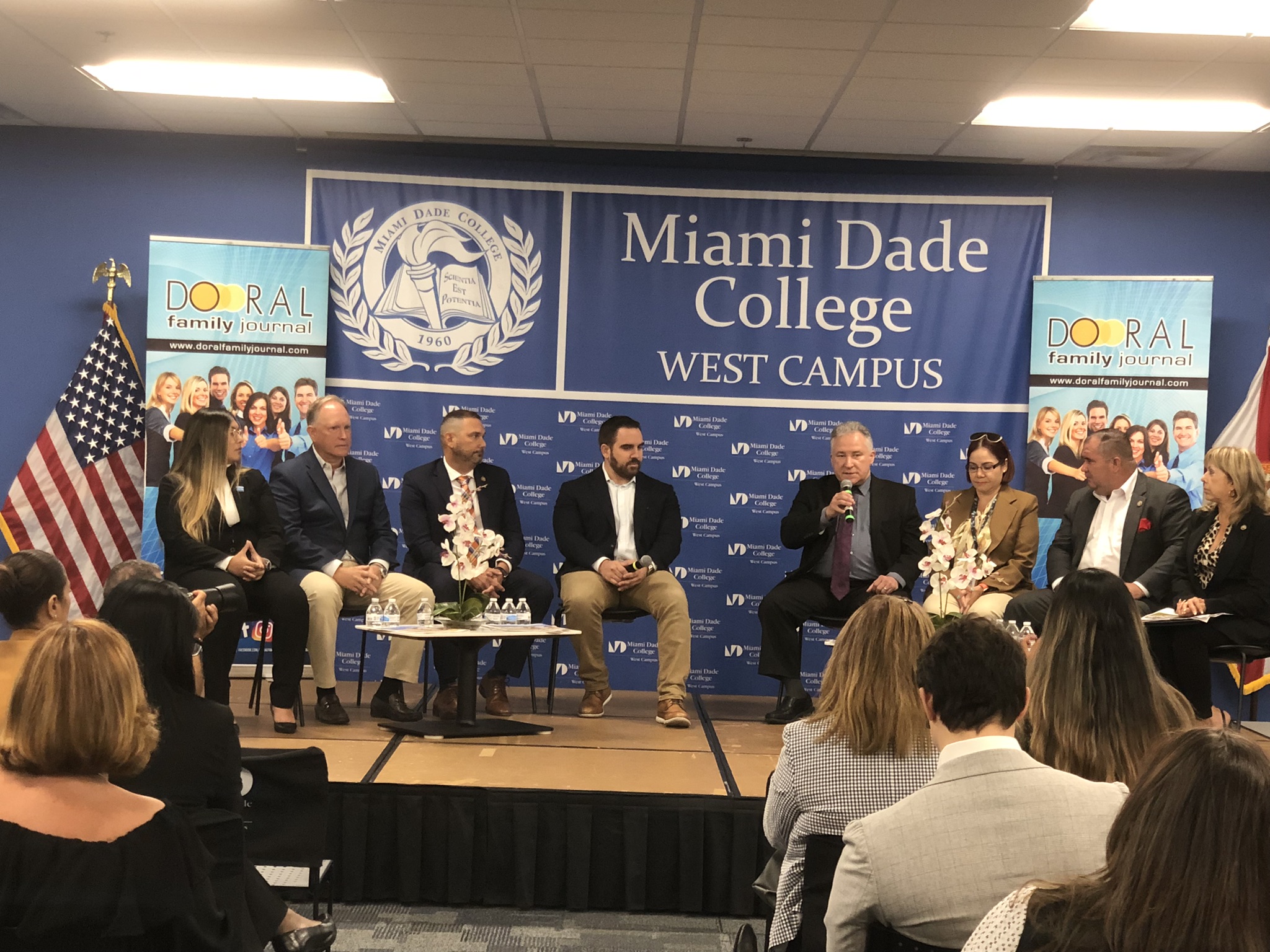 Professionals sitting on stage at the Miami Dade College West Campus speaking amongst each other and to crowd.
