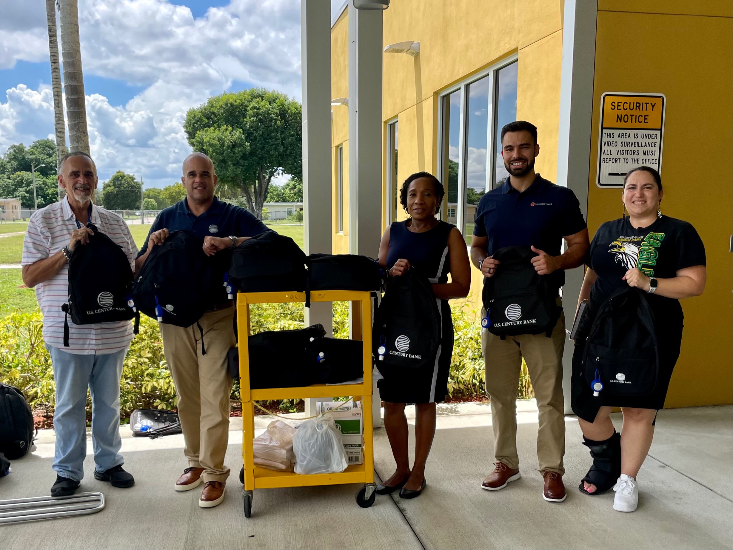 group of male and females employees carrying bookbags.