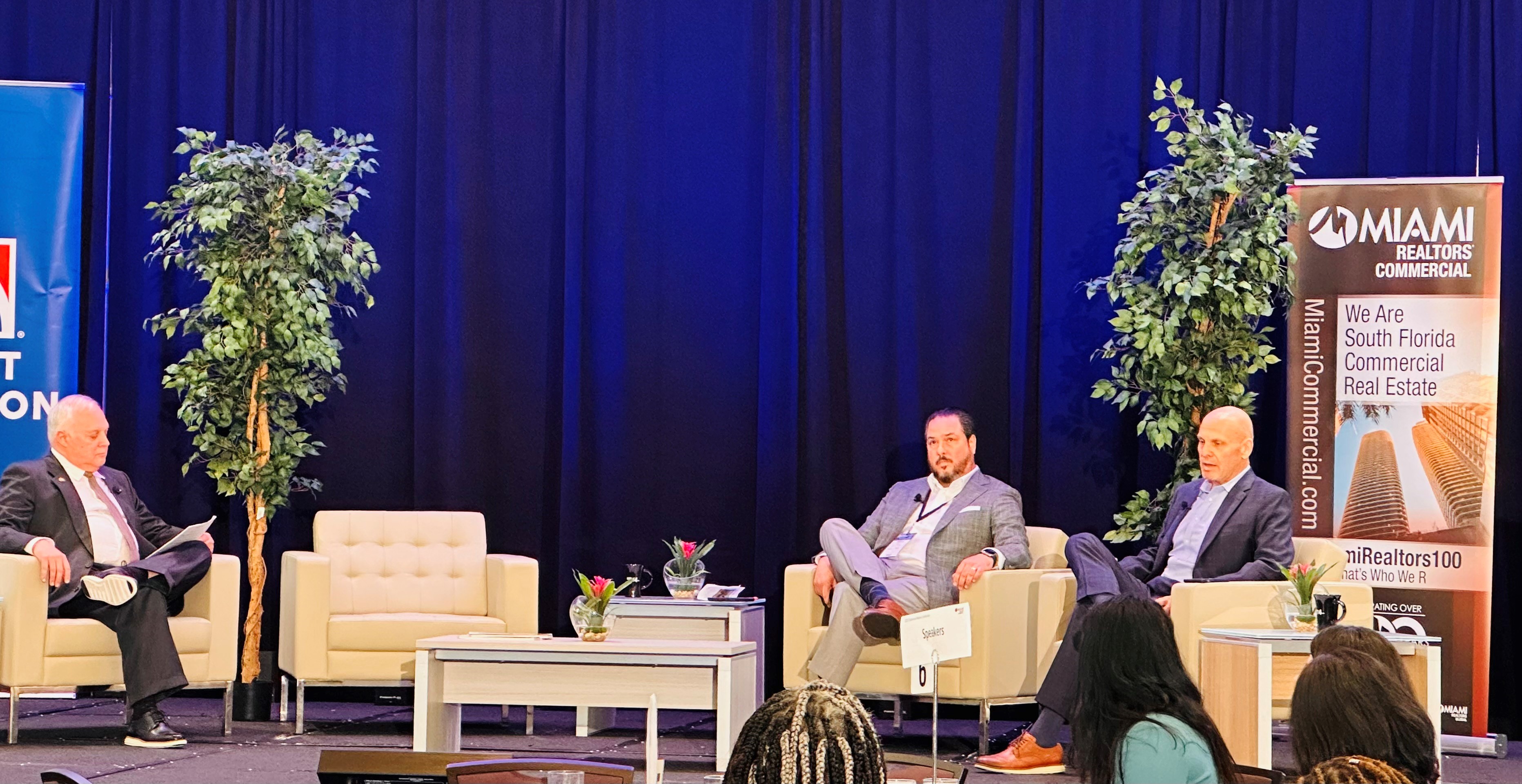 Business men sitting on stage at a conference.