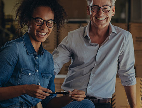 woman smiling holding a pen with man business partner